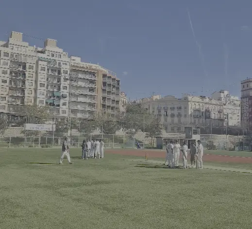 Cricket match with Valencia city buildings behind the ground